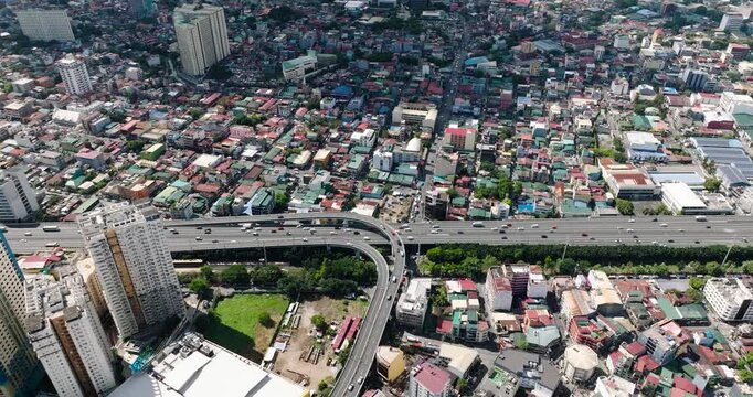 Drone view of vehicles running on skyway. Hotels and residential area in Makati, Metro Manila. Philippines.
