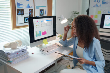 African American businesswoman working with laptop computer, PC in office. Female executive handling real estate project. Financial analysis. Data from graphs, charts, income, taxes of the company.