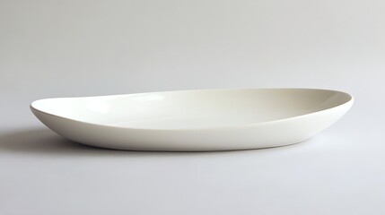 A white ceramic serving dish on a white surface.