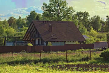 A small frame house with a brown roof covered with soft roofing, stylized as tiles.