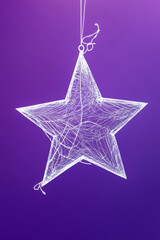 Obraz premium Suspended reflective star with white abstract lines on a solid purple backdrop