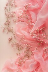 Fototapeta premium Soft Pink Scarf and Delicate Gypsophila Flowers on Pastel Beige Background