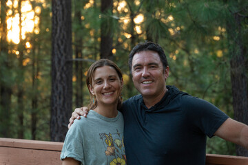 Obraz premium Joyful couple embracing nature at sunset in a serene forest retreat