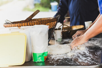 Homemade hand preparing bread dough on table.