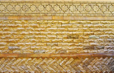 Old weathered wall with varied brick patterns and simple mosaic border at the top abstract monochromatic background texture