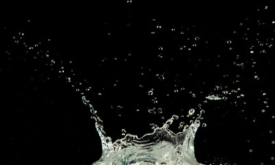 Crown water to object make curve drop explosion in ripple motion. Black background isolated. Crown Water splash on object to create shape form fluttering in droplet and wave.