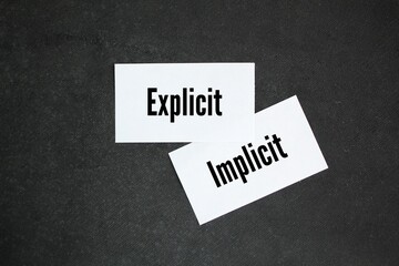 white paper with the words explicit and implicit. motivational words positive and negative