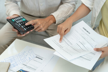 Stressed and headache asian couple with large bills or invoices no money to pay to expenses and credit card debt. shortage, Financial problems, mortgage, loan, bankruptcy, bankrupt, poor, empty wallet