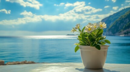 Vibrant flowers in a pot beside tranquil waters and scenic cliffs under a bright blue sky