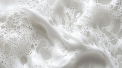 Naklejka premium Close-up of creamy white foam with bubbles creating a soft, textured surface.