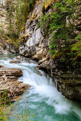 Fototapeta premium A waterfall is flowing down a rocky cliff