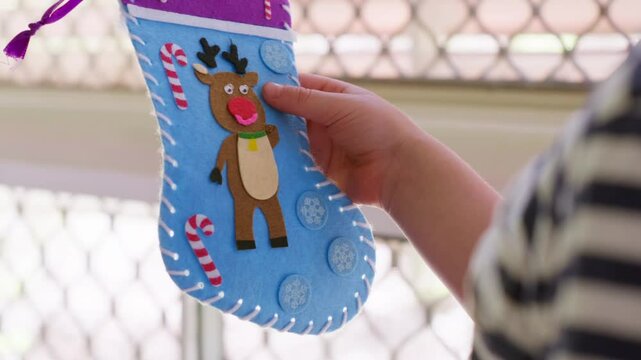 Young caucasian boy holding a Christmas stocking decoration