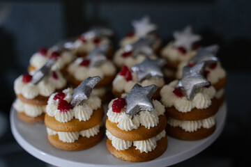 Cupcake with cream cheese, raspberries and silver stars on a dark background