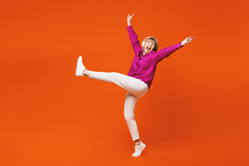 Full body elderly blonde woman 50s years old wear purple shirt casual clothes listen to music in...