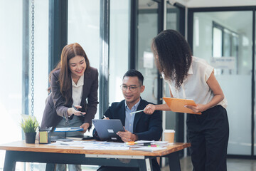 Collaborative Business Meeting: Three diverse professionals engage in a productive meeting, reviewing documents and discussing ideas in a modern office setting.  