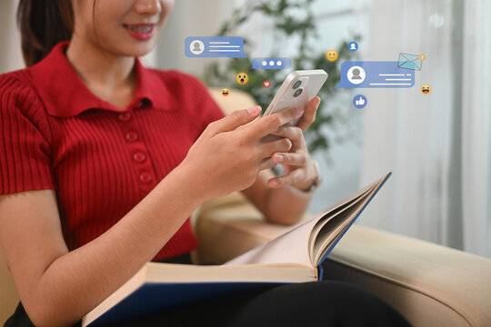 Young woman using smartphone with virtual social media and messaging icons floating around