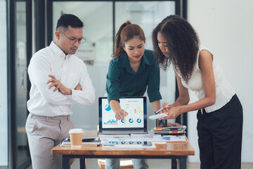 Business Professionals Analyze Data: A focused and collaborative team of diverse business professionals meticulously review data on a laptop and papers.