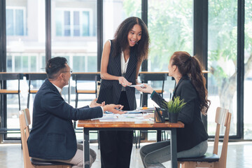 Business Deal Closed: A cheerful businesswoman hands over documents, sealing a successful business deal with two colleagues. The scene is filled with excitement and mutual respect.  