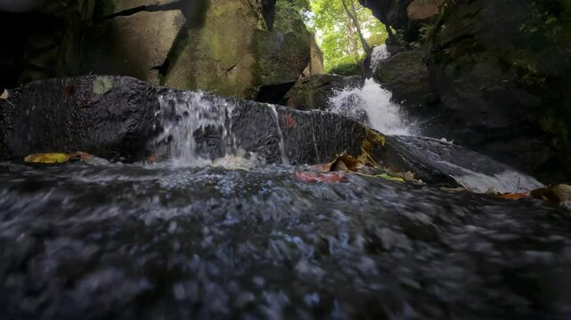 Slow-motion closeup footage of the Lumsdale Waterfall cascading on rocks in Derbyshire, England, UK