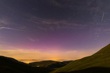 Perseids meteor shower lights up the night sky with falling stars and northern lights in Coll De La...