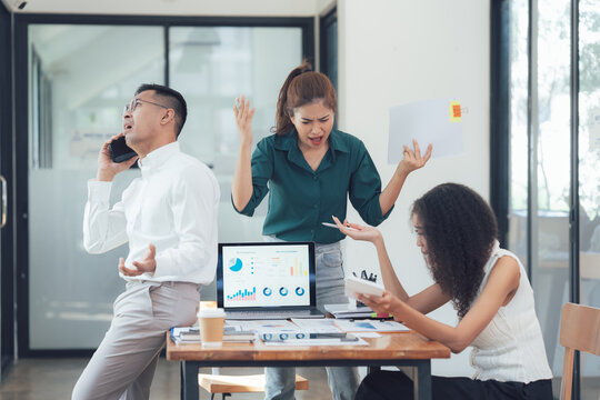 Office Chaos: A team of diverse business professionals grapples with a stressful situation in a modern office, showcasing the realities of workplace pressure and the challenges of collaboration.