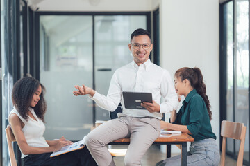 Modern Business Meeting: A diverse team of professionals engaged in a lively discussion, showcasing teamwork and collaboration in a modern office setting.