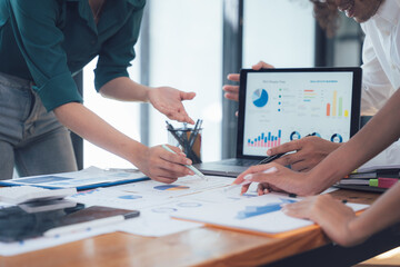 Collaborative Strategy Session: A diverse team of professionals huddle around a table, analyzing...