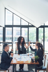 High-Five Success: Business team celebrates a successful project with a celebratory high-five. Modern office setting with large windows.
