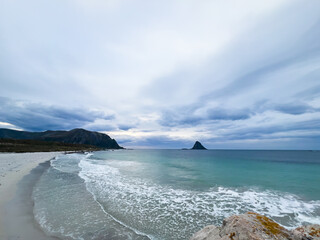 Serenity captured: a stunning beach with white sands and rocks meeting the turquoise waters of norway under a cloudy sky