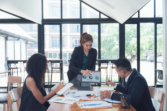 Business Presentation: A diverse team of professionals collaborates in a modern office setting, engaged in a presentation or brainstorming session, showcasing their expertise and ideas.