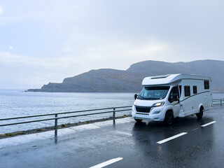 Scenic drive along the norwegian coast in a white camper van on a rainy autumn day