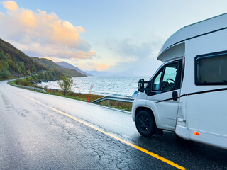 Obraz premium A motorhome parked by the road in the autumn landscape of the Lyngen Alps, Northern Norway, with mountains.