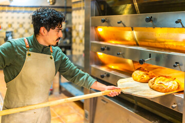 Man baking bread in a traditional oven