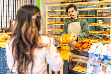 Woman buying artisan bread in a bakery