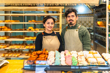 Portrait of a couple of young bakery shop owners