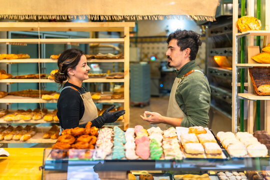 Workers of a bakery shop discussing in the counter