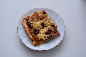 Slice of pizza on a beautiful white plate on a white background