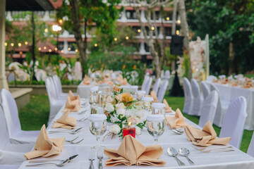 Long table with white table cloth and an elegant floral arrangement in the middle.