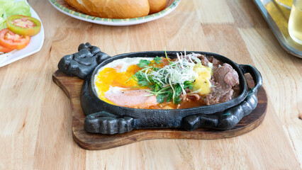Bo Ne. Vietnamese breakfast. Beef cooked in a hot plate with gravy, eggs and corn which is a westernized. Plate of beef dish in vietnamese