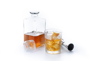 Old fashioned cocktail garnished with orange isolated on white background.