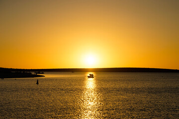 Chasing the Horizon: Boat in the Sun's Last Rays