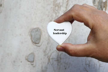 Servant leadership - man hold white wooden heart in hand