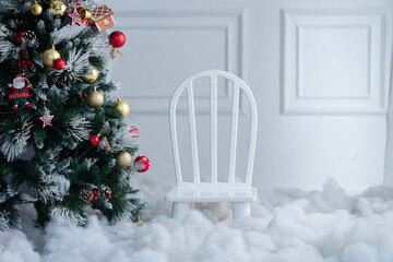 White chair on isolated Christmas background 2025, decorative Christmas tree with chair and snow, Christmas home interior with copy space, living room interior wall mockup with white small kids chair.