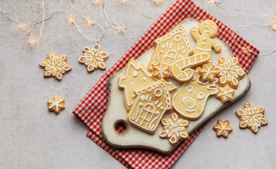 Christmas cookies decorated with icing lying on white cutting board