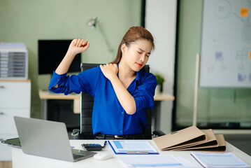 Overworked young Asian businesswoman office worker suffering from neck pain after had a long day