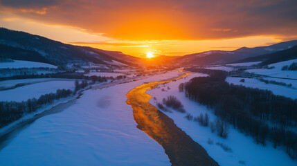 golden river winding through a snowy valley at sunset with distant hills