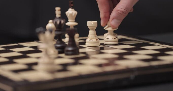 Caucasian man's hand making a move on a chessboard, capturing a white knight with a white bishop, 4K