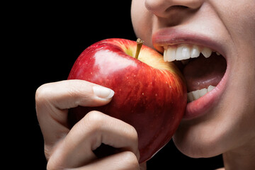 Dentadura perfecta de una mujer mordiendo una manzana. Generado con IA