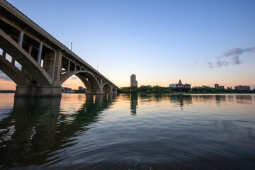 Naklejka premium A bridge spans a river with a city in the background