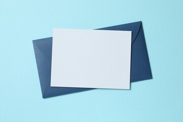 Top view photo with paper card and envelope on color background with empty space